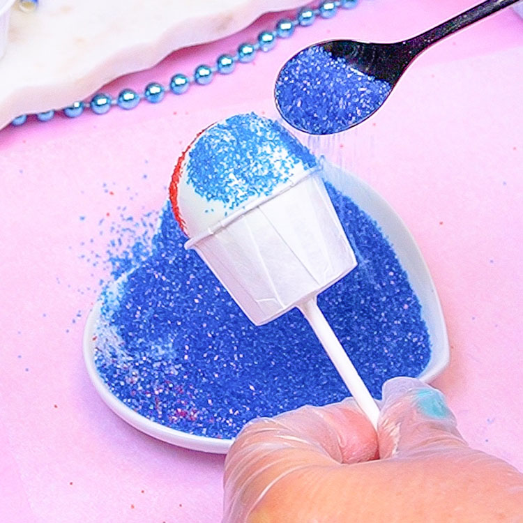 decorating snow cone cake pop with blue sanding sugar