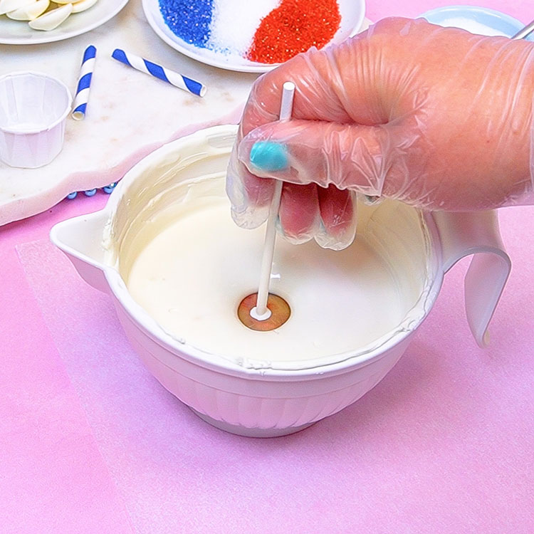 dipping cake pop into melted white chocolate