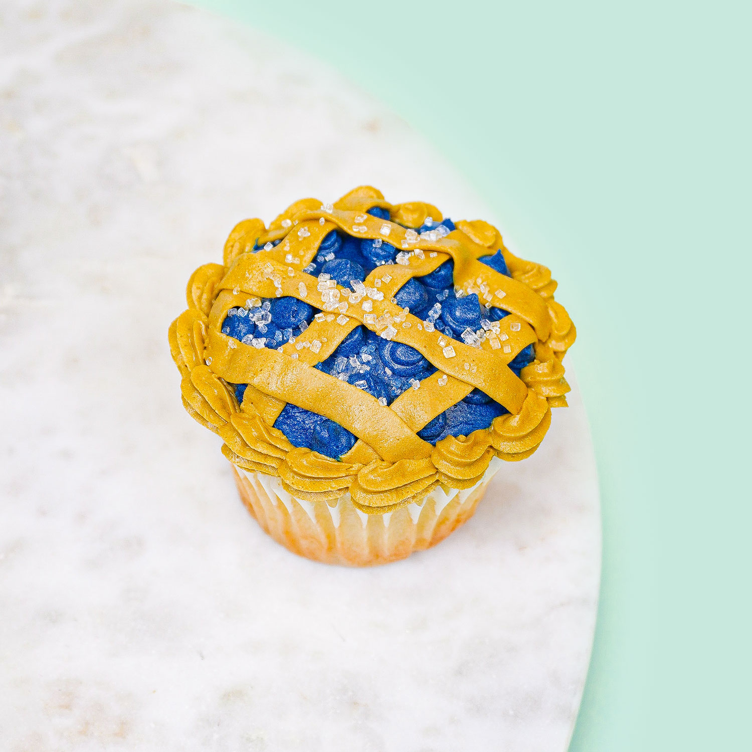 cupcake decorated to look like a blueberry lattice pie
